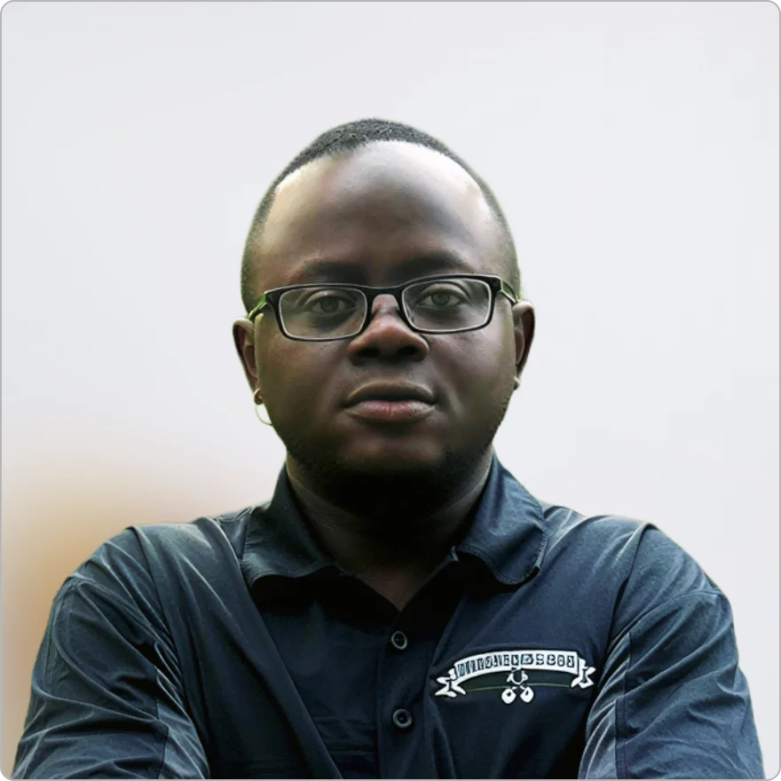 Professional man with glasses wearing a black collared shirt against a clean background.