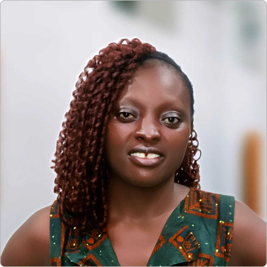 Professional woman with styled braided hair wearing a green pattern dress.