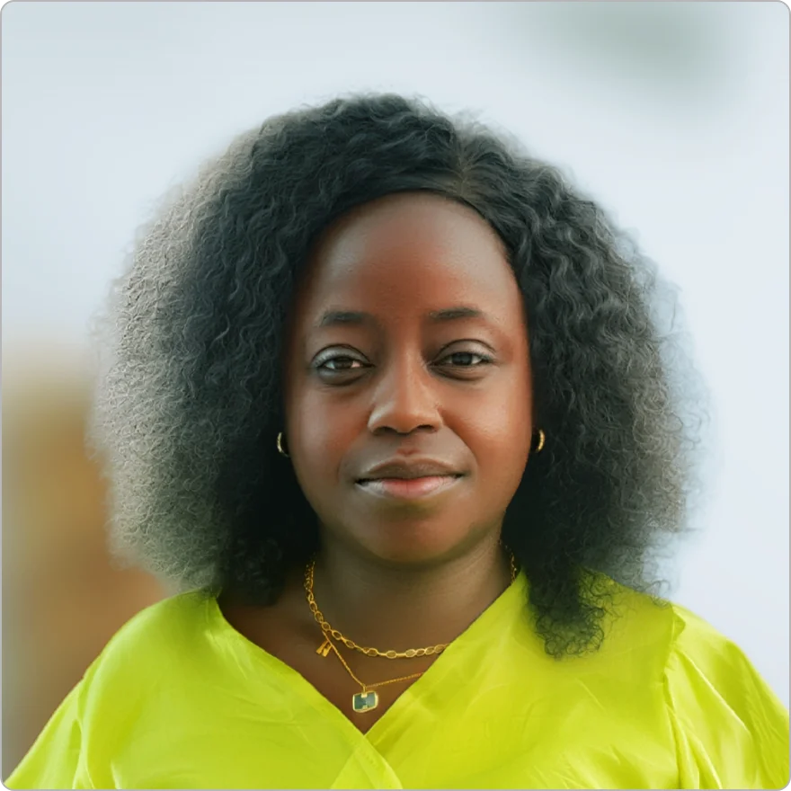 Professional woman with curly black hair wearing a bright lime green top and a gold necklace.