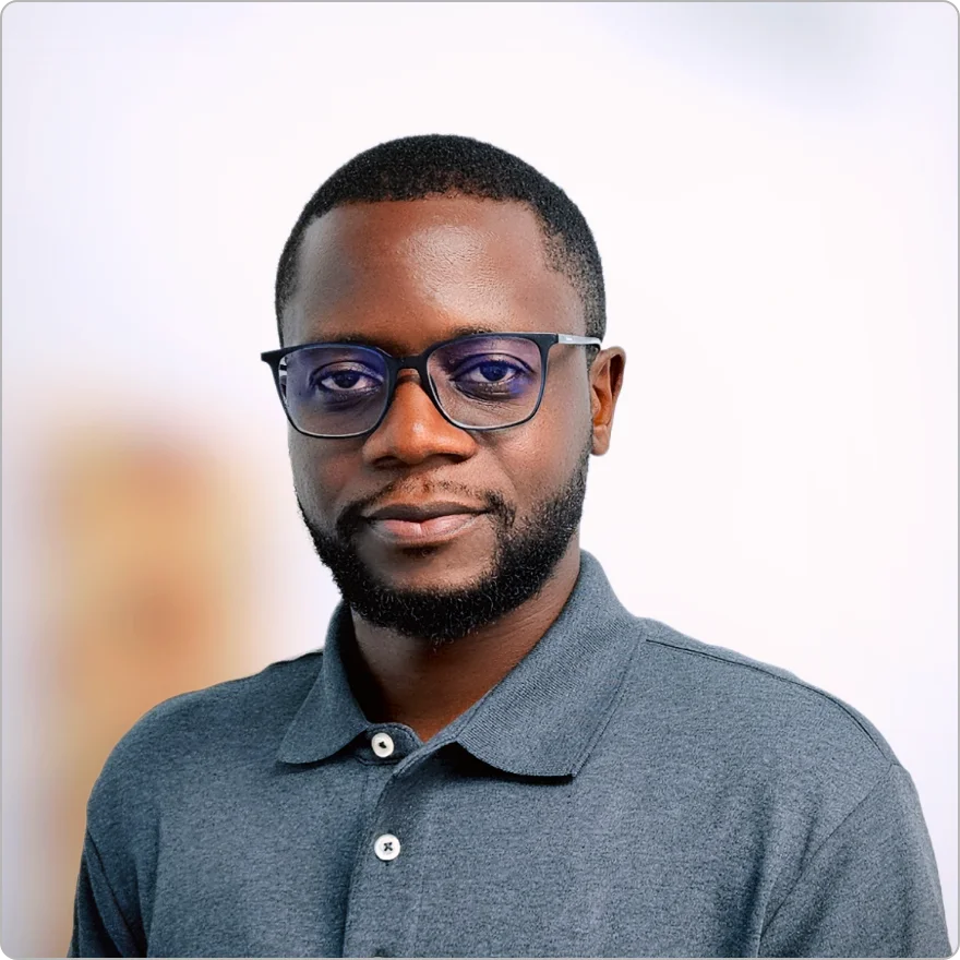 Smiling man wearing a black beret, glasses, and a black turtleneck sweater.